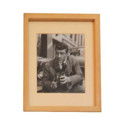 Fotografía en blanco y negro de hombre sujetando cámara antigua